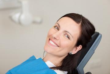 A woman smiling while getting a dental exam